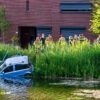 Auto schiet van de weg en belandt in vijver in Tilburg, vrouw en kind uit auto gehaald