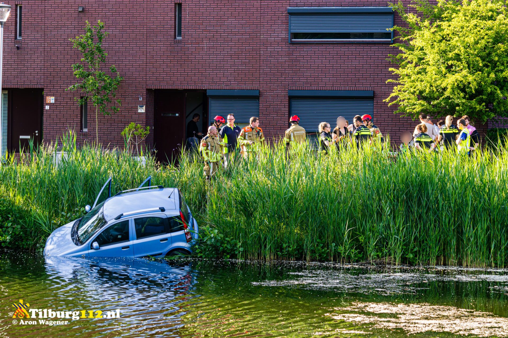 Auto schiet van de weg en belandt in vijver in Tilburg, vrouw en kind uit auto gehaald